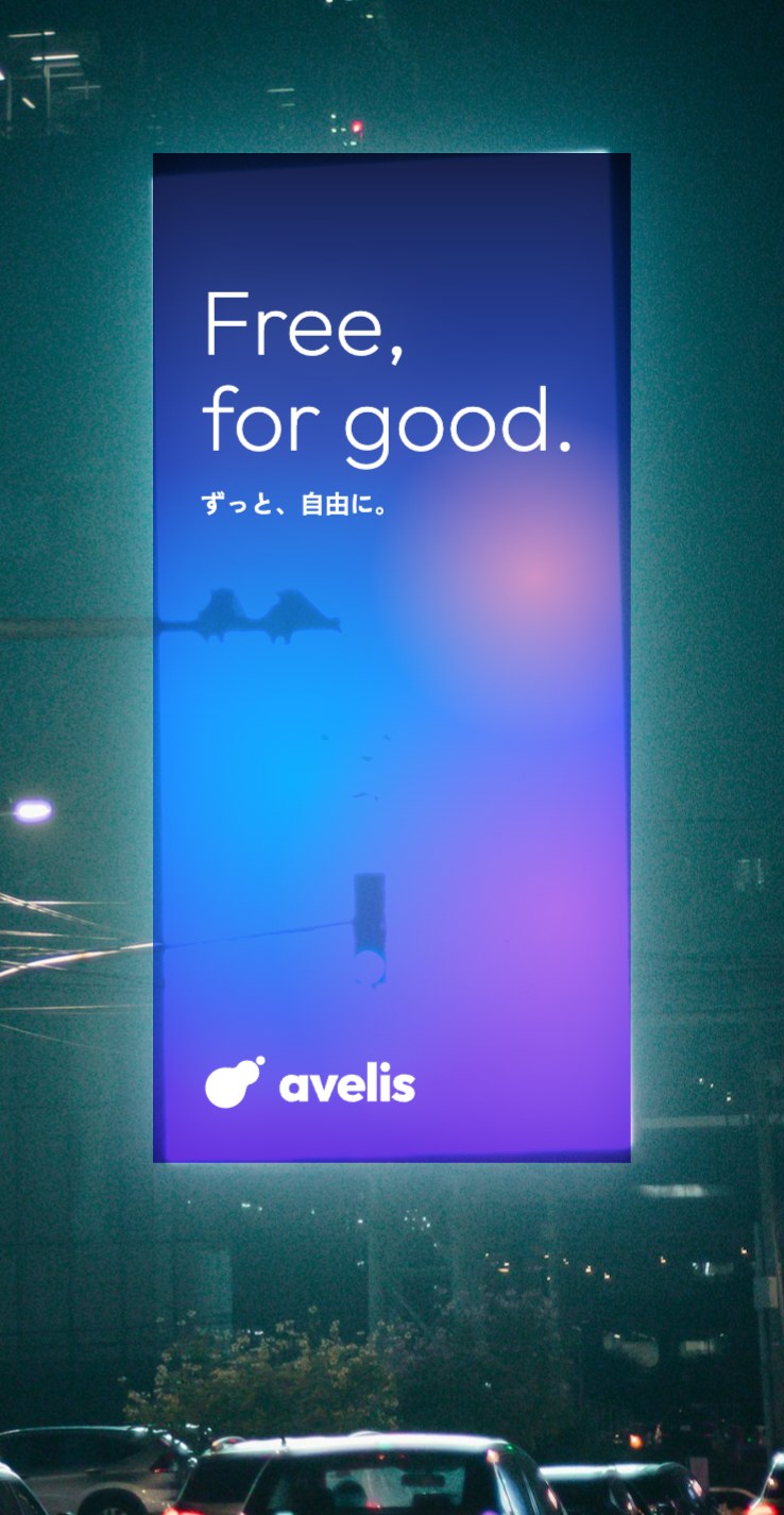 夜の街のビルの大型ビジョンに、avelis の広告が映っているイメージ